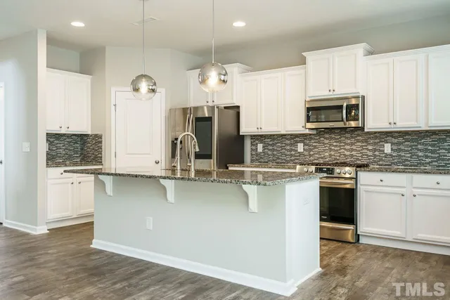 a kitchen with stainless steel appliances a stove sink and microwave
