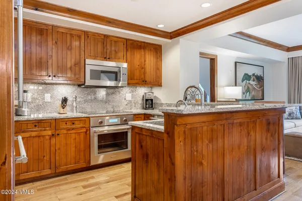 a kitchen with stainless steel appliances granite countertop a sink stove and microwave