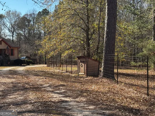 a view of a yard with wooden fence