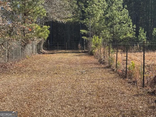 a view of a yard with wooden fence