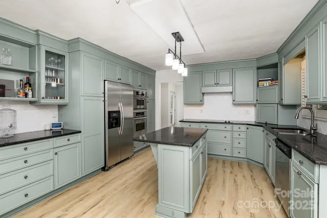 a kitchen with granite countertop a sink stove and refrigerator