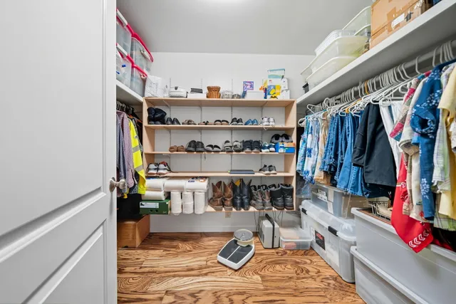 a view of walk in closet with clothes and shoes