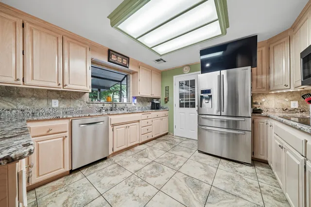 a kitchen with stainless steel appliances granite countertop a refrigerator sink and cabinets