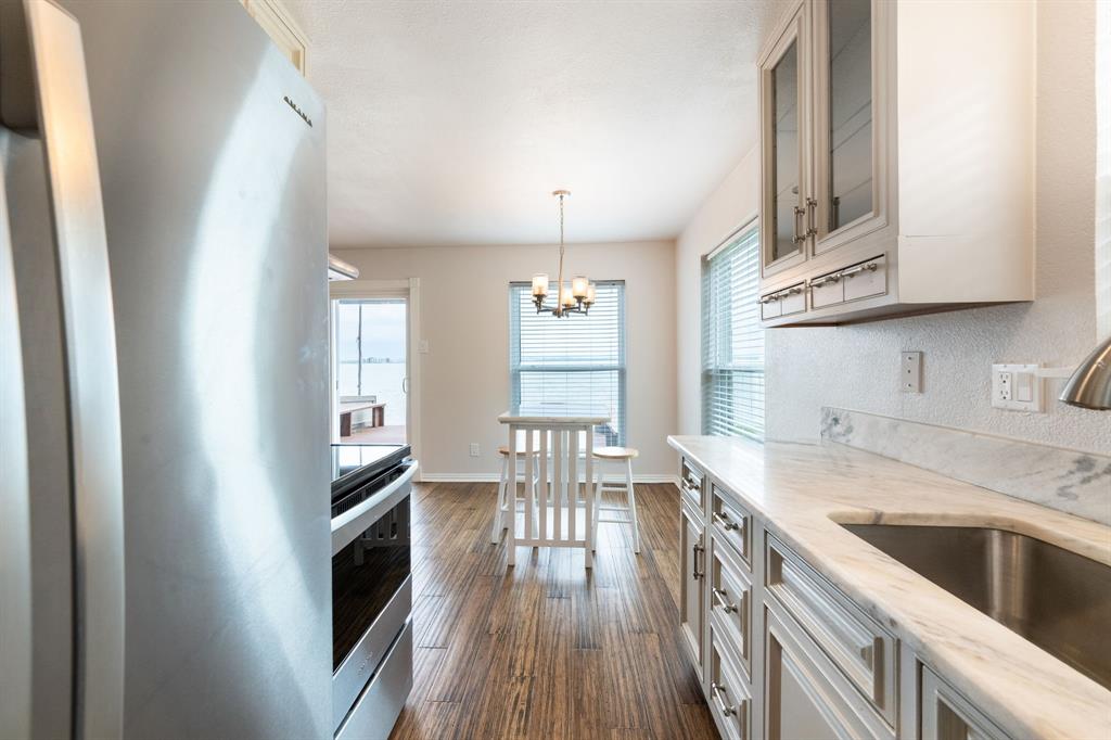 4610 Chaha Road, Unit 106 Garland, TX 75043 - Photo 11 of 25 a kitchen with granite countertop a sink dishwasher a stove and a refrigerator with wooden floor