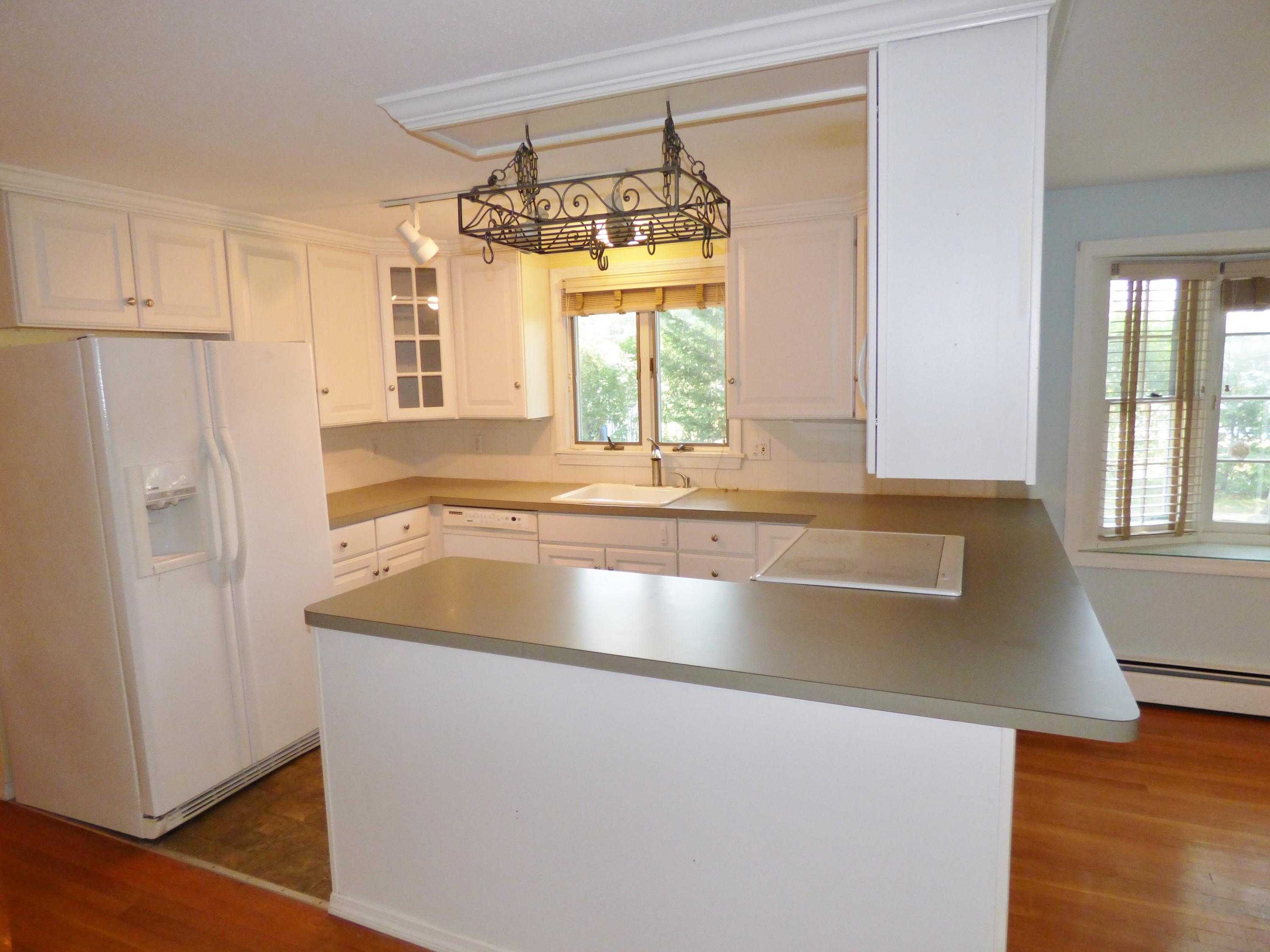 195 Ansel Howland Road Centerville, MA 02632 - Photo 5 of 22 a view of a kitchen with a sink and a refrigerator