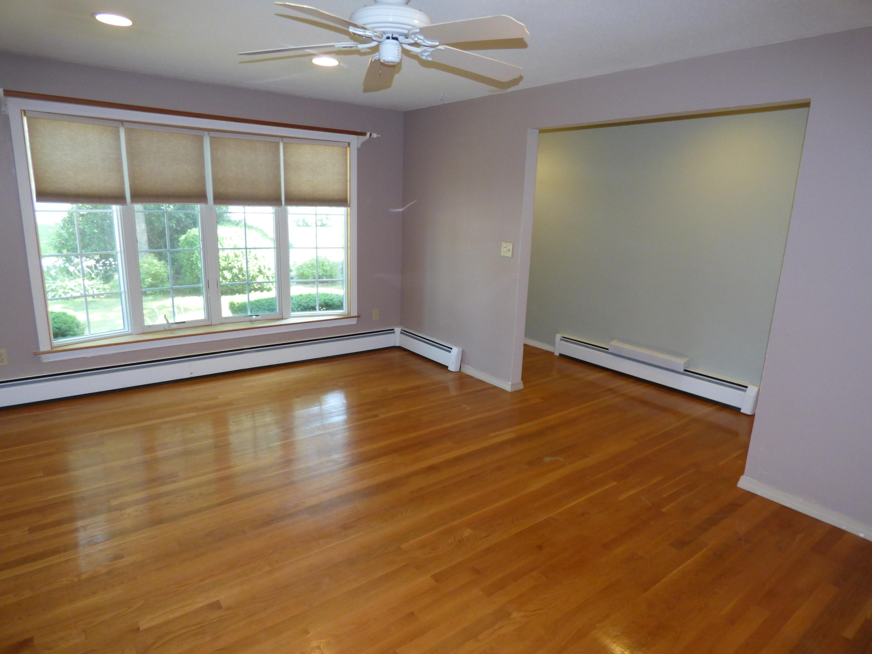 195 Ansel Howland Road Centerville, MA 02632 - Photo 9 of 22 an empty room with wooden floor and windows