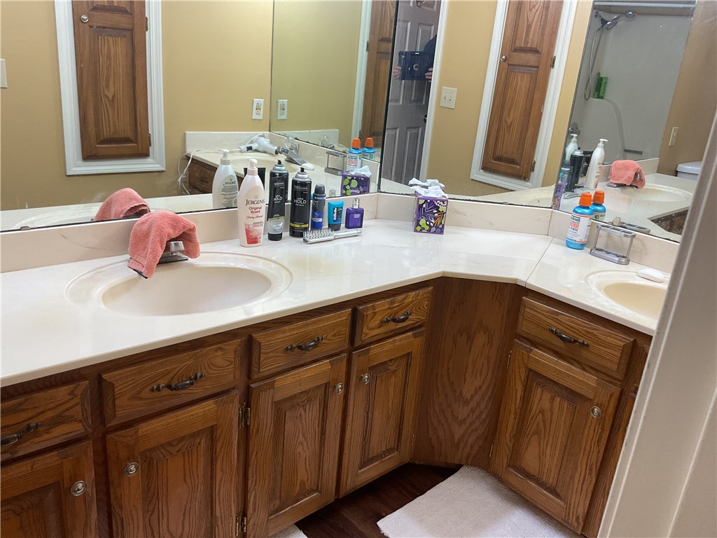 1800 Capps Road, Unit 8 Harrison, AR 72601 - Photo 12 of 14 Dual vanity featuring integrated sinks, light-toned countertops, and wood-finish cabinetry with decorative hardware