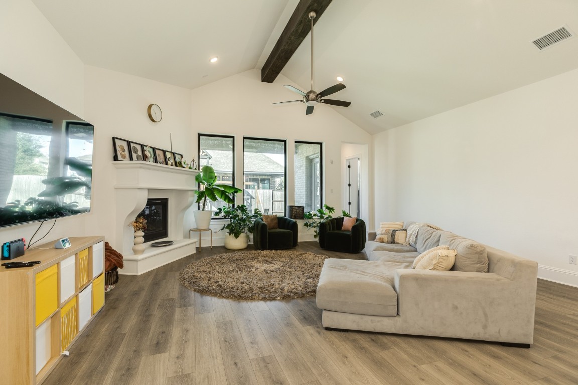 10102 Brush Way Rosharon, TX 77583 - Photo 48 of 50 The family room features an open floor plan that seamlessly connects to the kitchen area. It boasts a vaulted ceiling with wooden beam, oversized windows overlooking the covered back patio, and a corner gas fireplace.