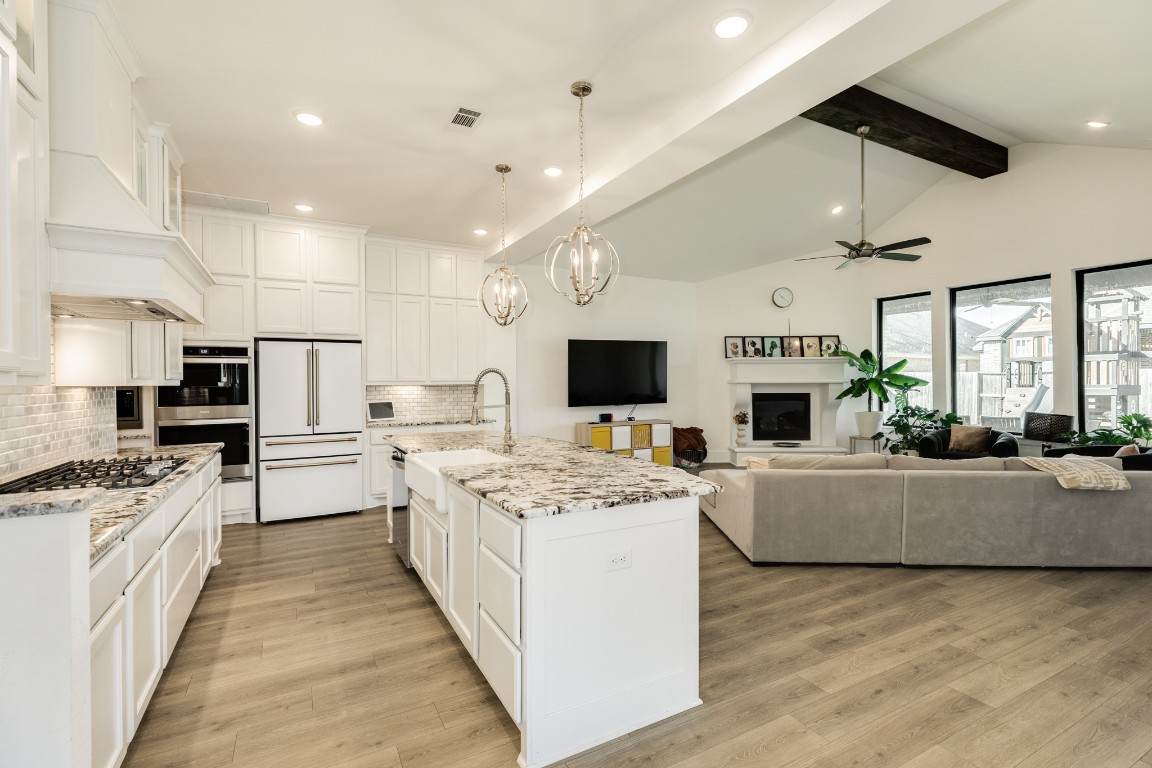 10102 Brush Way Rosharon, TX 77583 - Photo 13 of 50 The kitchen features modern updates, including gold trim, ample cabinet space, granite countertops, a barn-style sink, recessed lighting, a five-burner range top, and double ovens.