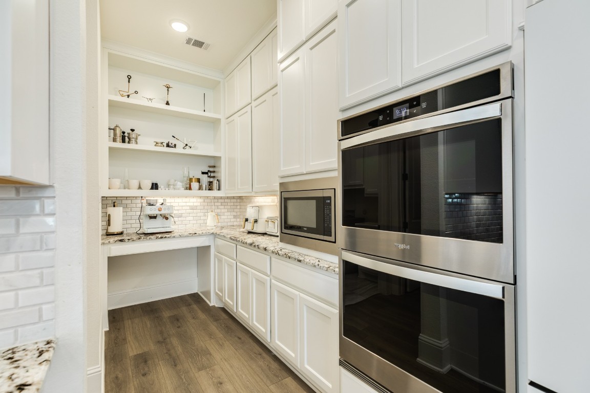 10102 Brush Way Rosharon, TX 77583 - Photo 17 of 50 Features include double ovens, a butler's area with a workstation and ample storage, and recessed lighting. The chef of the family will appreciate this extra space adjacent to the kitchen.