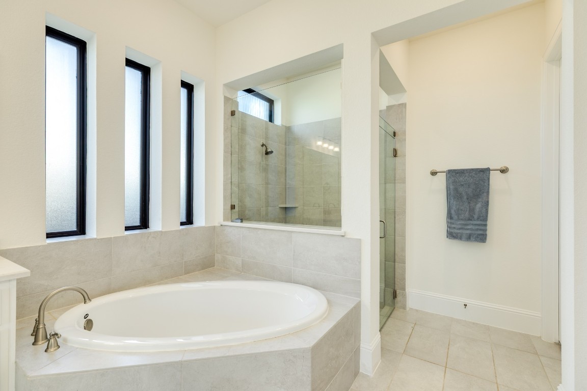 10102 Brush Way Rosharon, TX 77583 - Photo 24 of 50 Primary soaking tub with frosted windows, allowing natural light, and a glass walk-in shower.