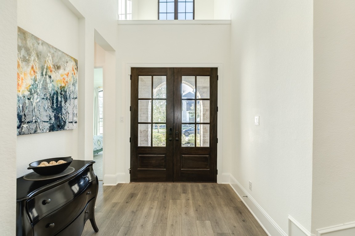 10102 Brush Way Rosharon, TX 77583 - Photo 3 of 50 Upon entering through the beautiful double doors, you are greeted to the right with a guest suite, featuring beautiful wooden floors and high ceilings.
