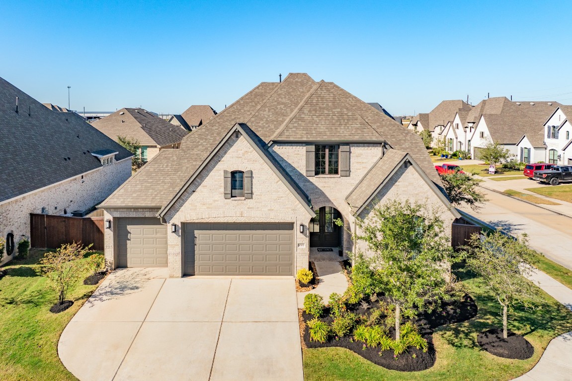 10102 Brush Way Rosharon, TX 77583 - Photo 35 of 50 Aerial view showcasing the front of the new home with its attractive landscaping and a spacious triple driveway leading to the three-car garage.