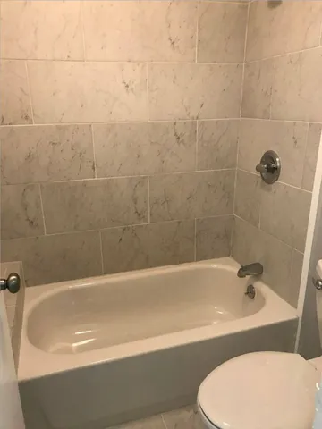 a bathroom with a bathtub and toilet