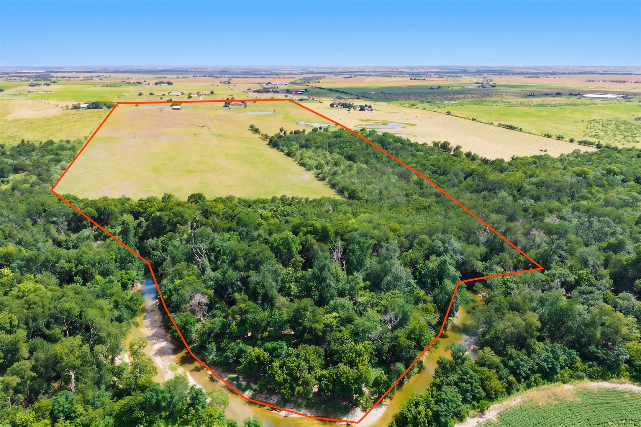 20145 Janak Road Coupland, TX 78615 - Photo 34 of 40 Discover expansive acreage bordering a serene creek, offering both cleared and wooded sections for diverse use.