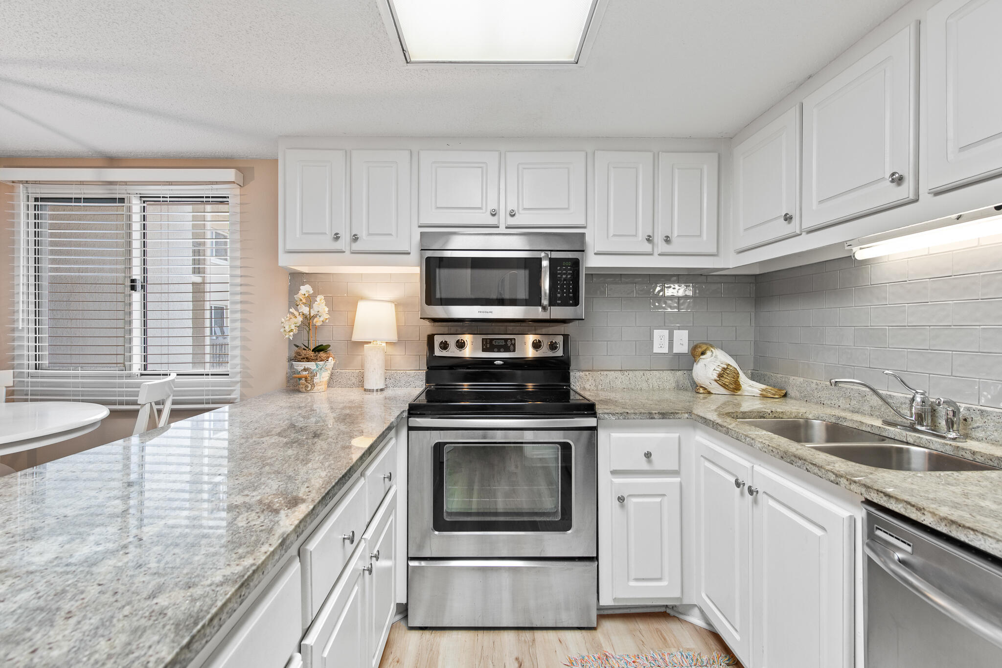 23223 Front Beach Road, Unit 113 Panama City Beach, FL 32413 - Photo 19 of 67 a kitchen with granite countertop a stove a sink and a microwave