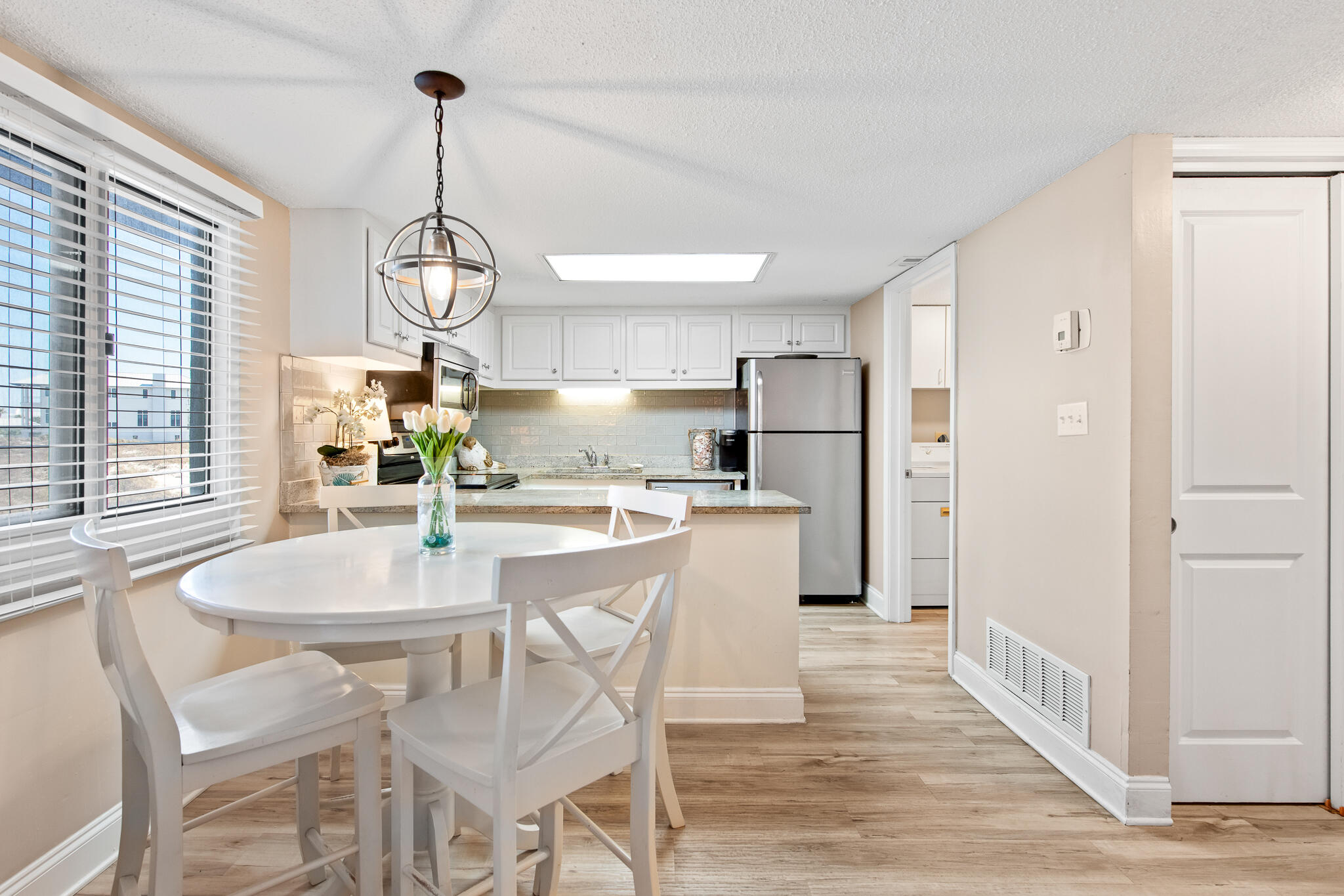 23223 Front Beach Road, Unit 113 Panama City Beach, FL 32413 - Photo 22 of 67 a kitchen with stainless steel appliances kitchen island granite countertop a table chairs and a wooden floor