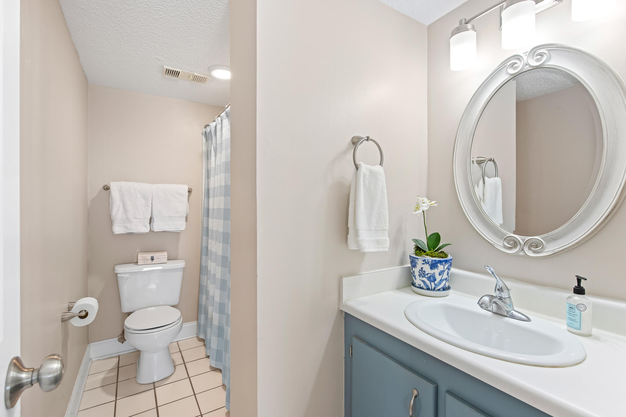 23223 Front Beach Road, Unit 113 Panama City Beach, FL 32413 - Photo 36 of 67 a bathroom with a granite countertop toilet a sink and a mirror