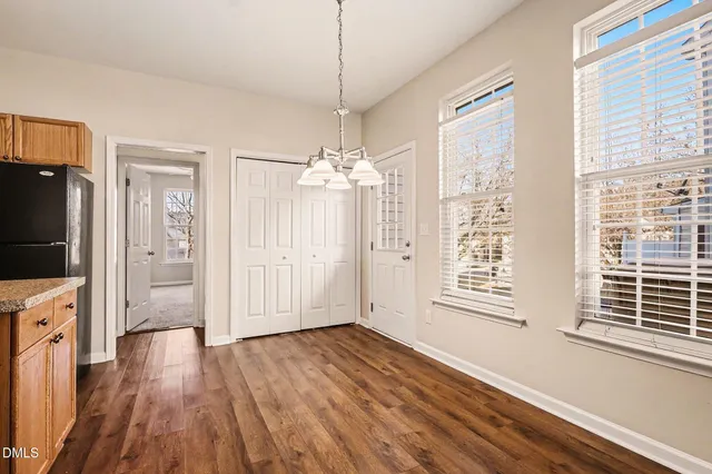 a view of a room with wooden floor fireplace and windows