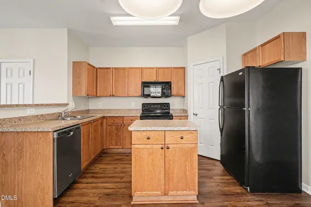 a kitchen with stainless steel appliances granite countertop a refrigerator stove and sink
