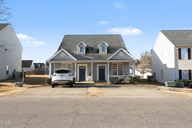 a front view of a house with cars parked