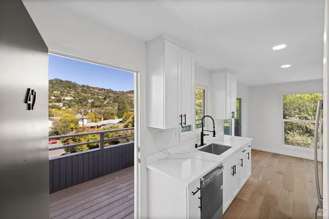 a kitchen with a sink and wooden floor