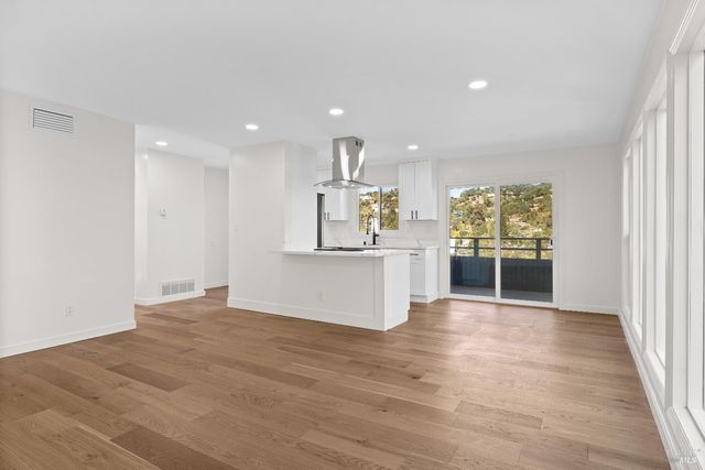 a view of a kitchen with a refrigerator a stove top oven and cabinets