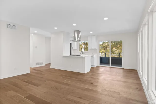 a view of a kitchen with a refrigerator a stove top oven and cabinets