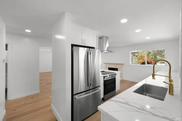 a kitchen with stainless steel appliances a refrigerator sink and stove