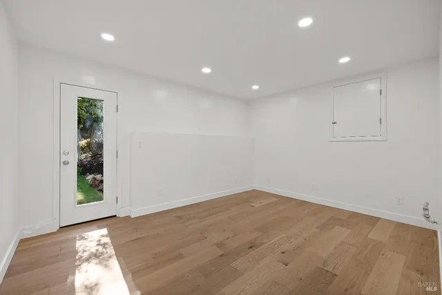 an empty room with wooden floor and entrance