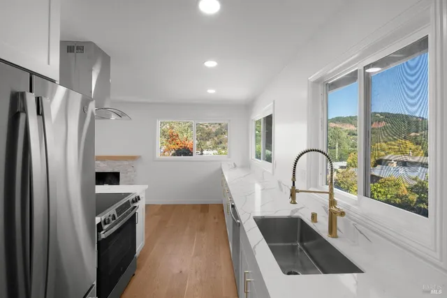 a kitchen with white cabinets and a refrigerator