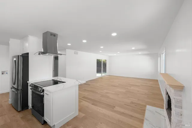 a kitchen with kitchen island stainless steel appliances a sink stove and refrigerator