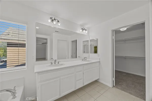 a spacious bathroom with a double vanity sink mirror and shower