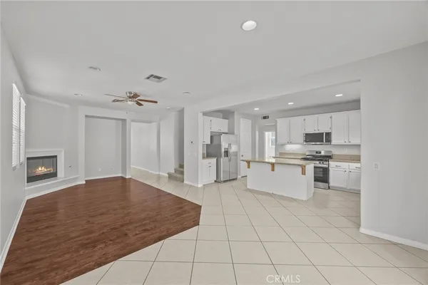 a large white kitchen with kitchen island a sink stainless steel appliances and cabinets
