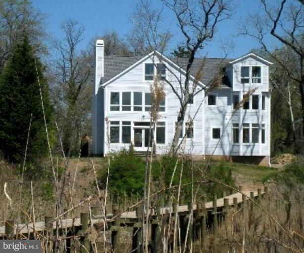 1405 Sharps Point Road Annapolis, MD 21409 - Photo 7 of 14 a view of a white house next to a yard with large trees