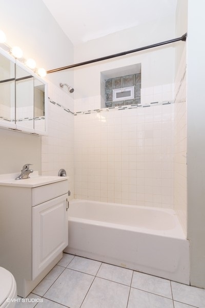 1312 West Nelson Street, Unit 1 Chicago, IL 60657 - Photo 11 of 12 a bathroom with a sink mirror vanity and toilet