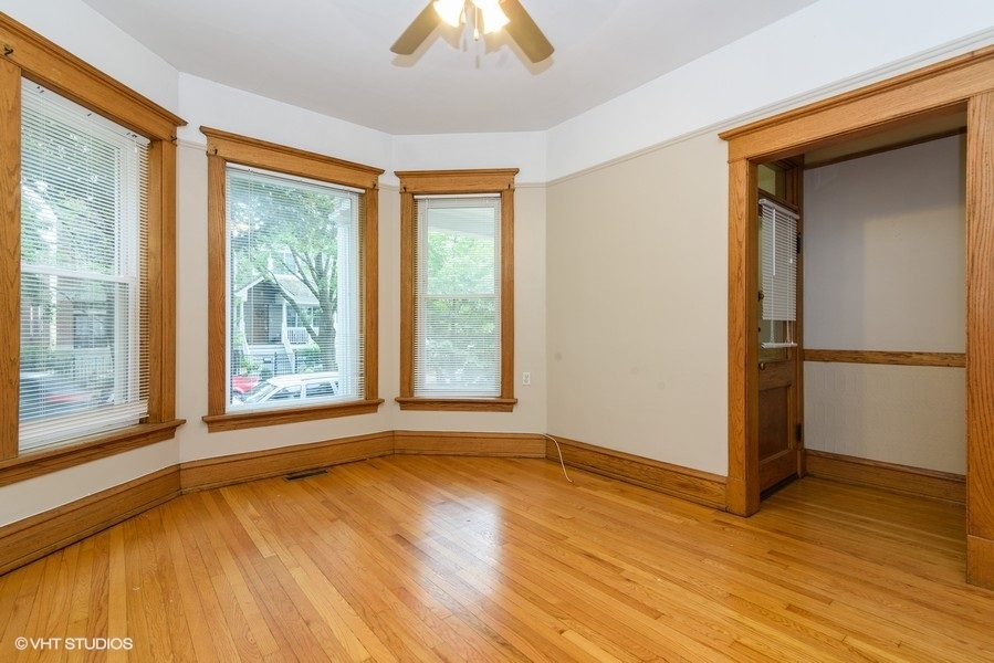 1312 West Nelson Street, Unit 1 Chicago, IL 60657 - Photo 3 of 12 a view of an empty room with wooden floor and a window