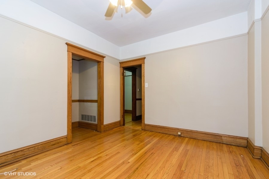 1312 West Nelson Street, Unit 1 Chicago, IL 60657 - Photo 4 of 12 a view of empty room with wooden floor and fan