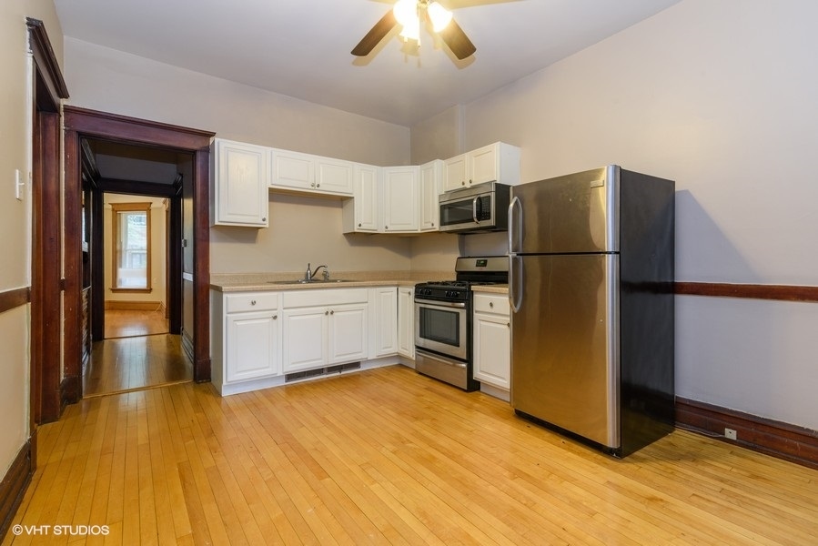 1312 West Nelson Street, Unit 1 Chicago, IL 60657 - Photo 6 of 12 a kitchen with a refrigerator a stove and a microwave