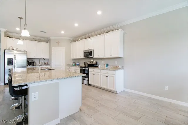 a kitchen with white cabinets and stainless steel appliances