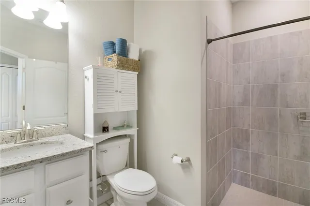 a bathroom with a granite countertop sink toilet a mirror and shower