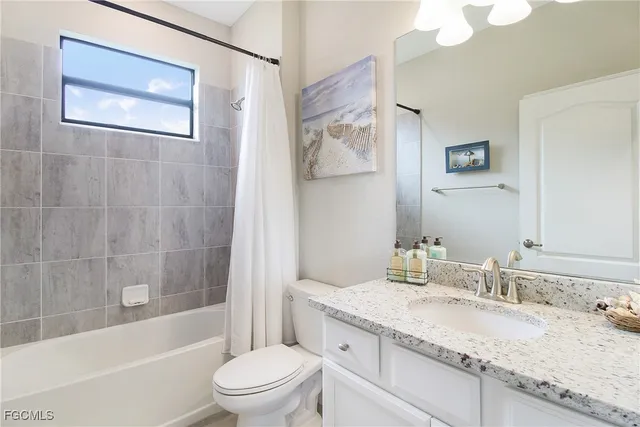 a bathroom with a granite countertop sink a toilet and shower