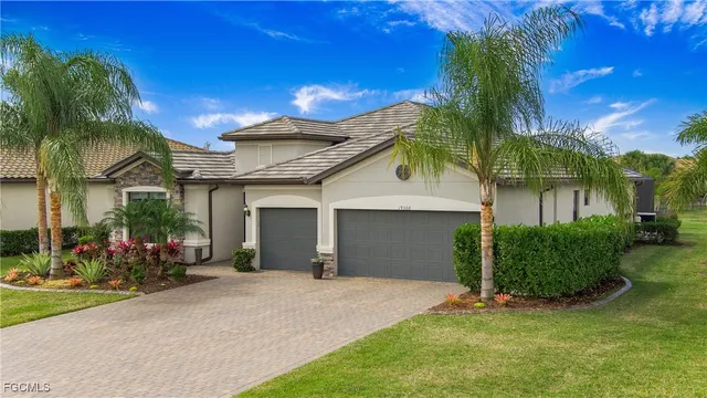 a view of a house with a yard and palm trees