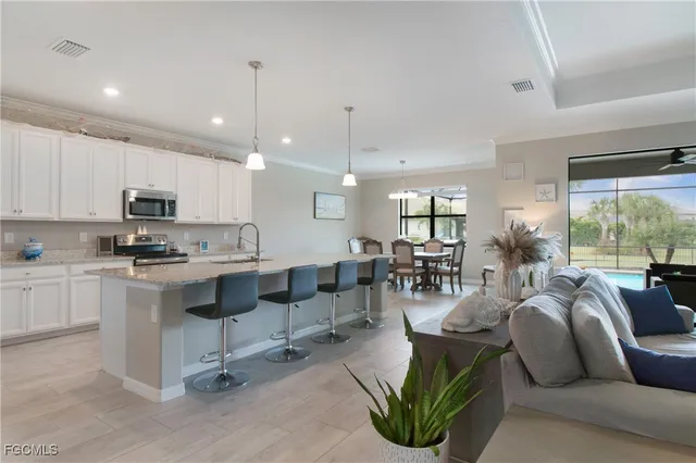 a living room with furniture kitchen view and a large window