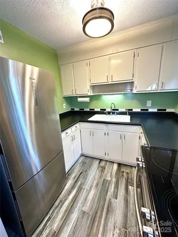 a kitchen with a sink a refrigerator a stove and cabinets