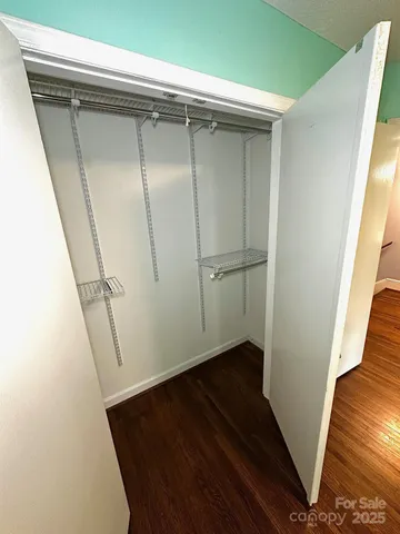 a view of walk in closet with wooden floor