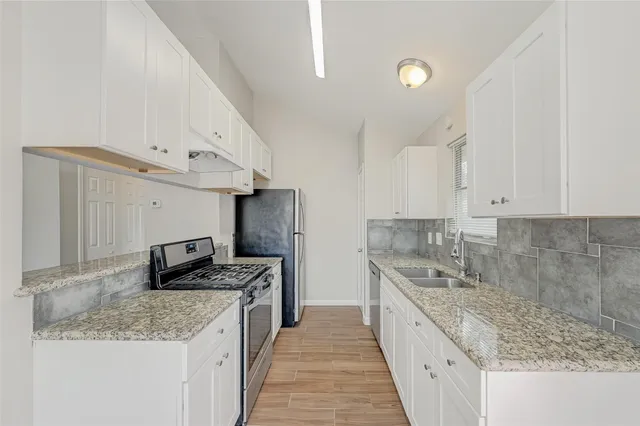 a kitchen with stainless steel appliances granite countertop a sink stove and refrigerator