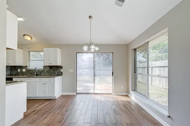 a kitchen with granite countertop wooden floors and white cabinets