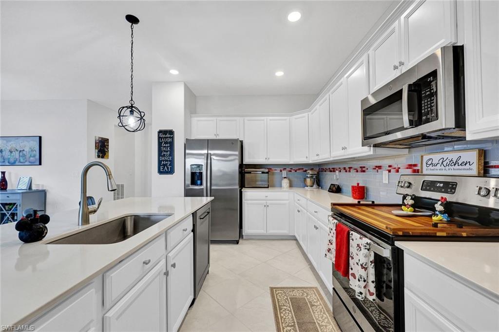 2622 Scarlet Way Naples, FL 34120 - Photo 5 of 24 a kitchen with stainless steel appliances granite countertop a sink a stove and a wooden floors