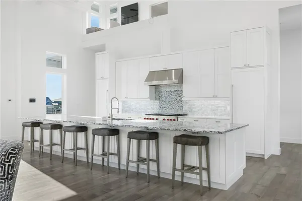 a kitchen with stainless steel appliances granite countertop a stove a sink and a refrigerator